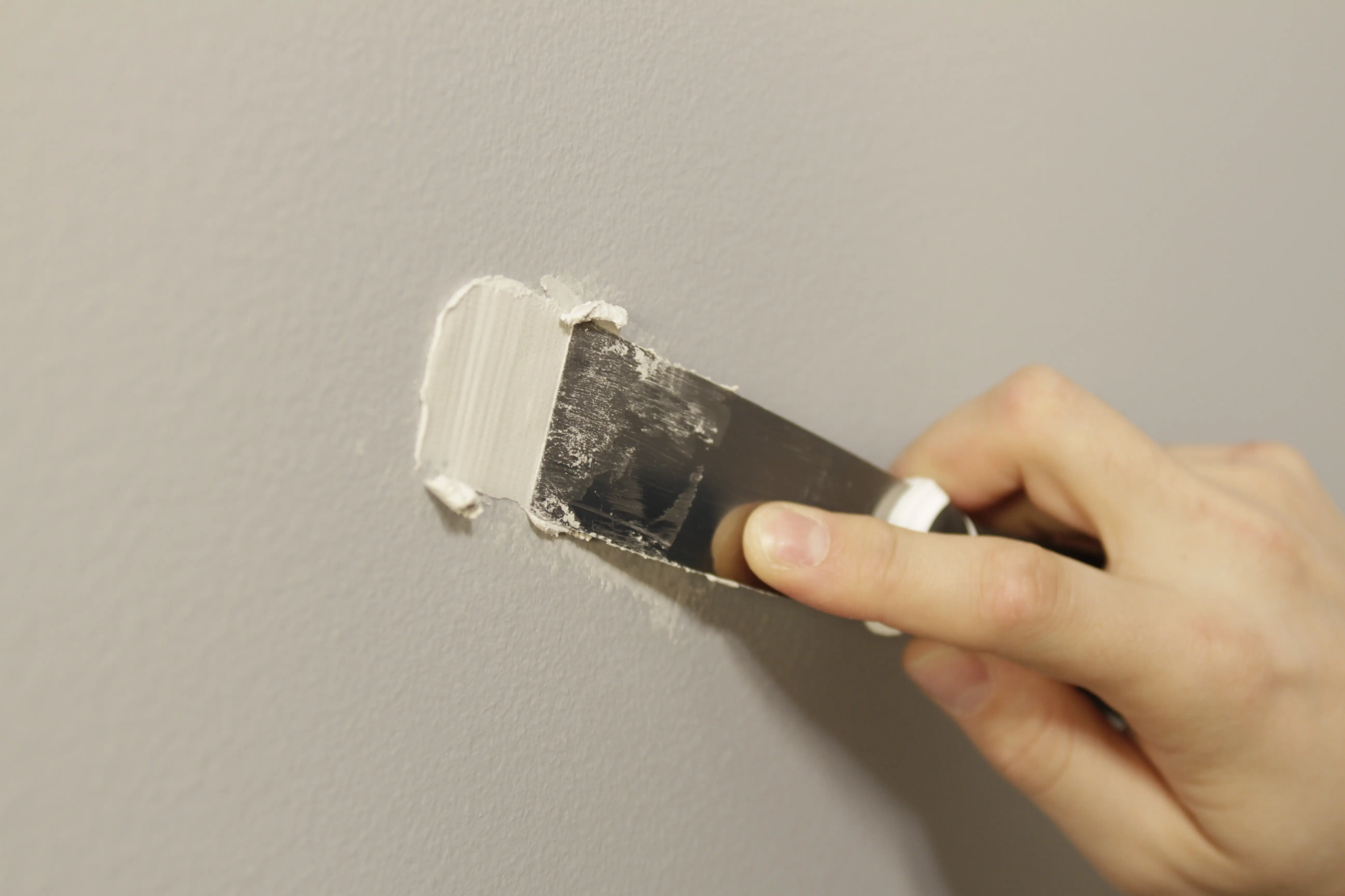 Especialista realizando repasos de pintura y sellado en acabados de obra nueva
